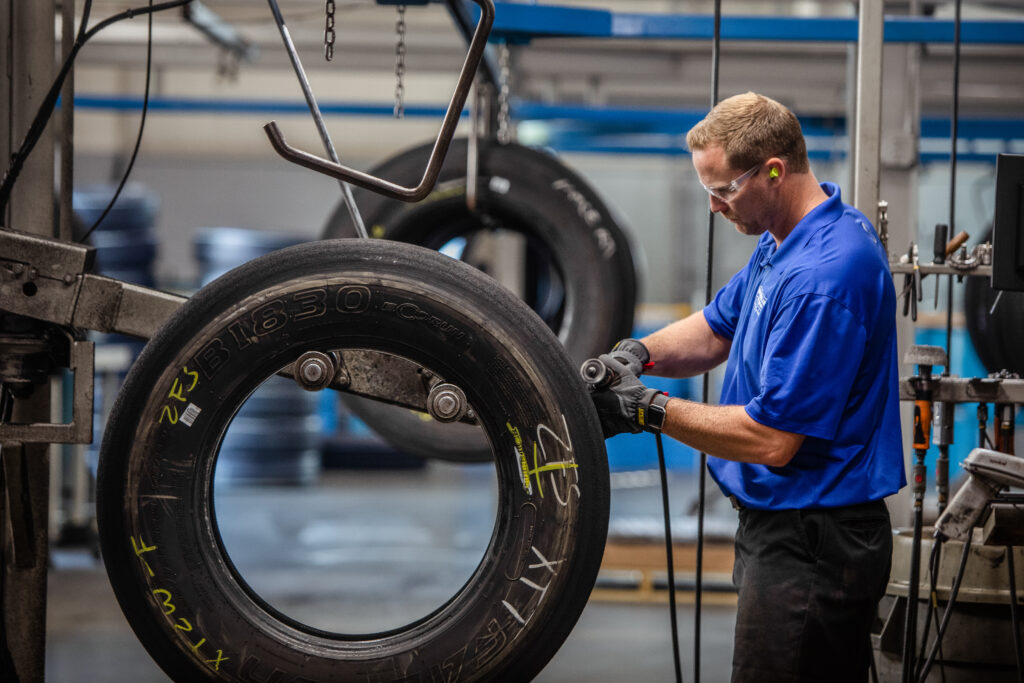 An AcuTread® technician perfects the buffing of the tire casing's old and worn tread before applying new rubber.