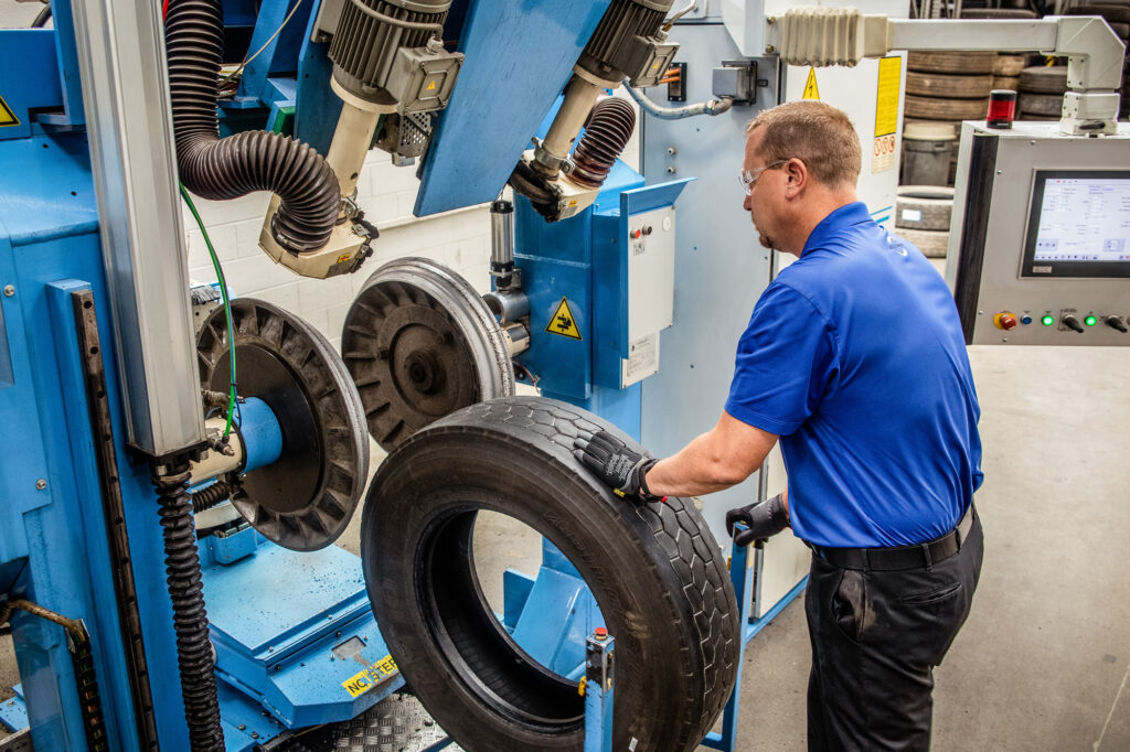 A Wonderland Tire employee uses AcuTread® Computerized Buffing technology to remove the old, worn tread for retreading.