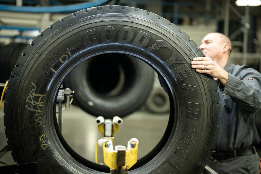 A trained AcuTread® technician inspects a commercial Goodyear tire casing.