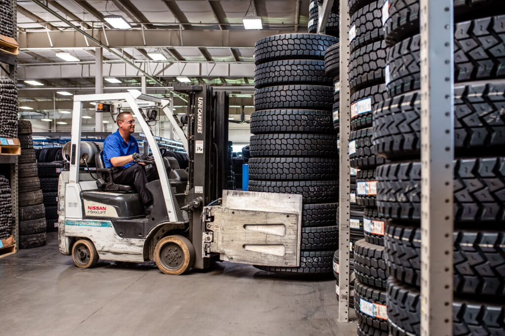 A Wonderland Tire employee moves finished AcuTread® retreaded tires with a forklift in the remanufacturing plant.