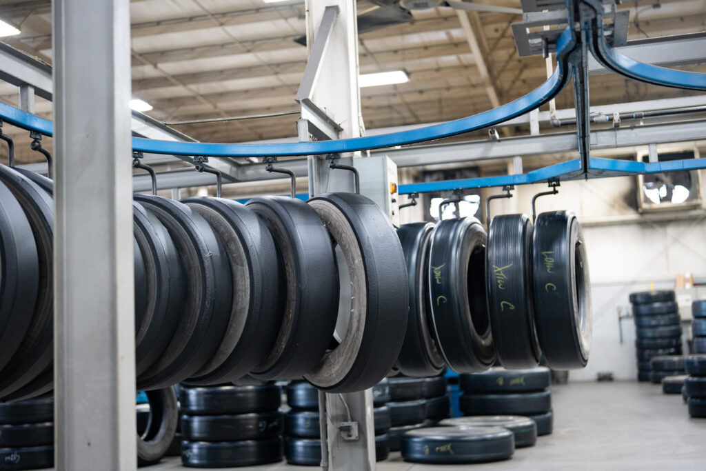 Tires that have had new rubber applied wait to be cure-molded at an AcuTread remanufacturing plant.