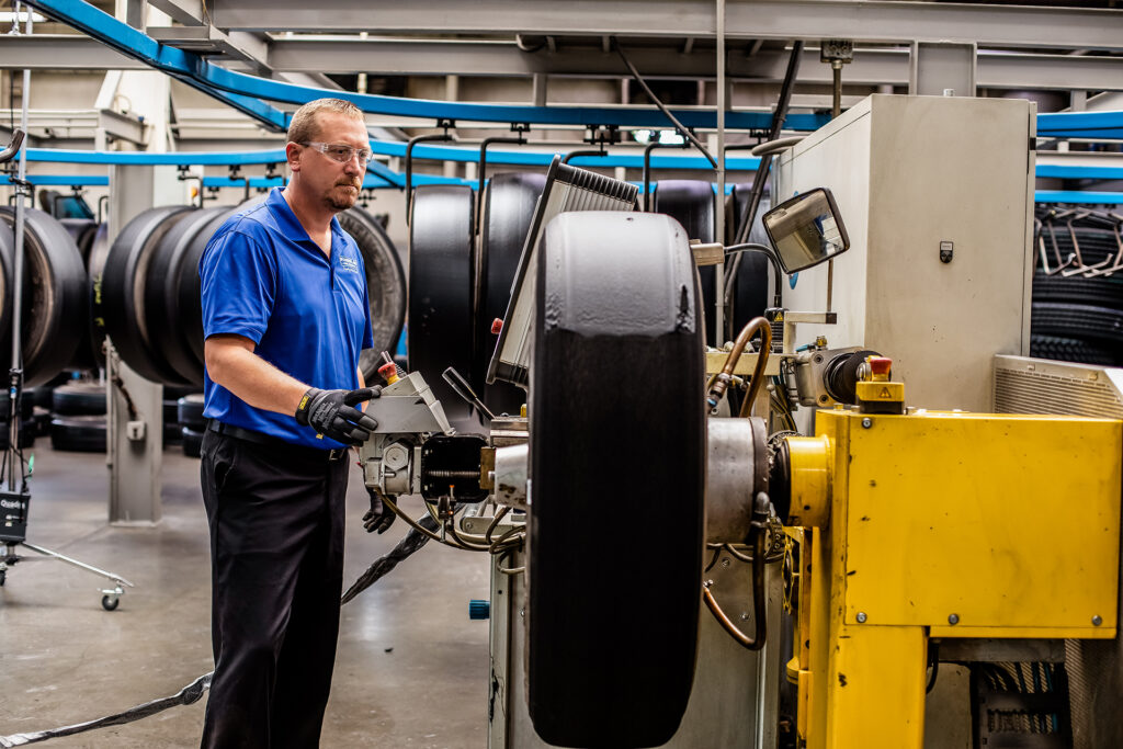 A thin layer of high-tack, uncured cushion rubber is applied to a buffed tire casing.