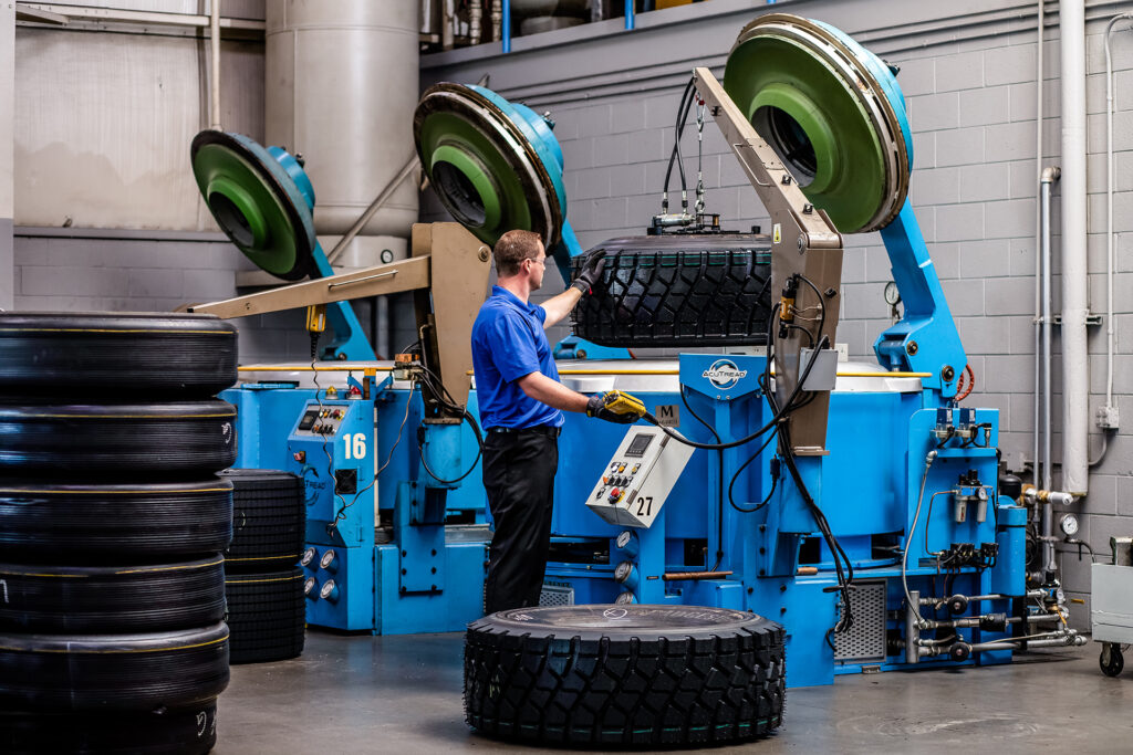 An AcuTread® technician removes a remanufactured tire from the segmented curing press.