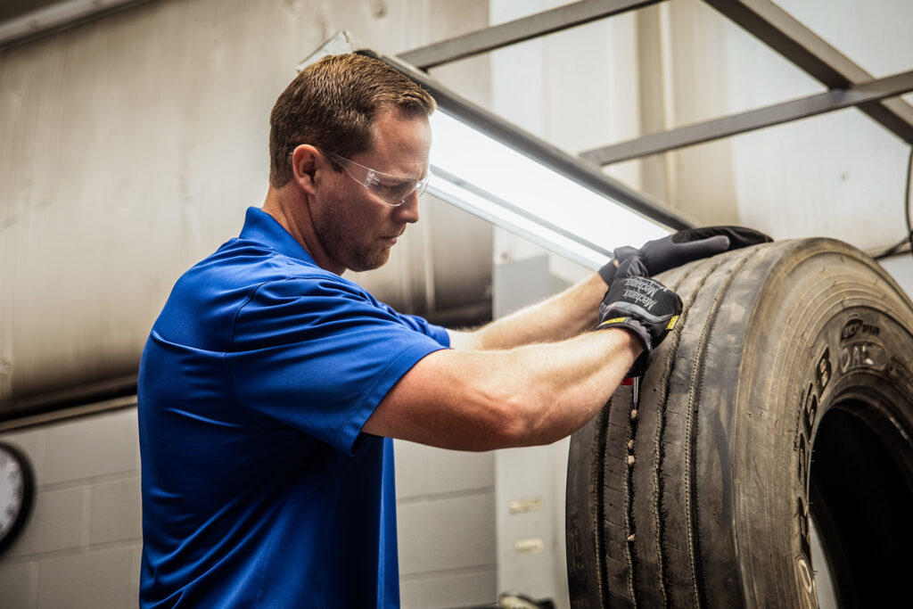 An AcuTread® technician checks a worn tire casing for micro-porosity and injuries.