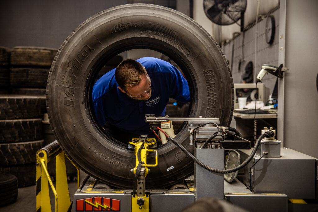 An AcuTread® tire technician inspects a premium tire casing.