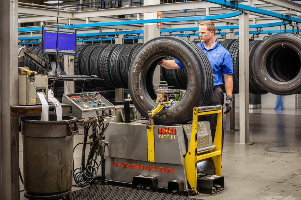 An AcuTread® technician inspects a newly remanufactured tire for quality.