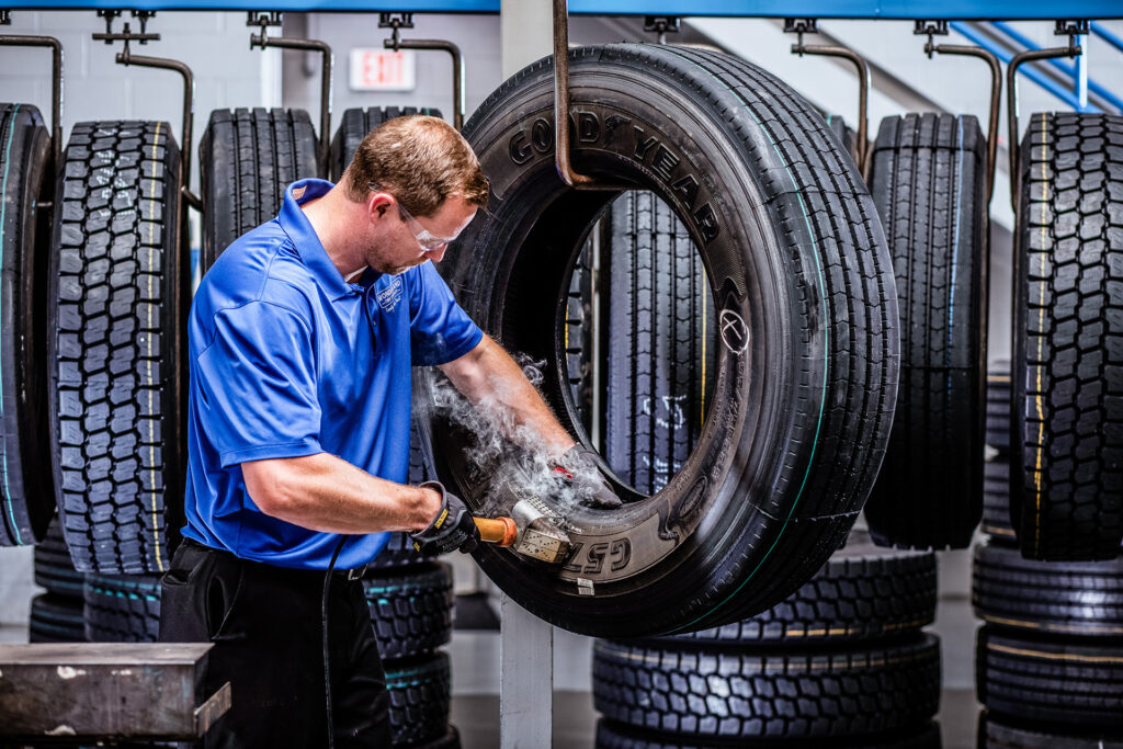 An AcuTread® technician applies branding to the finished retread product.